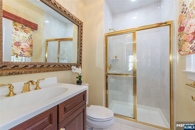 bathroom featuring vanity, tile patterned floors, toilet, and walk in shower