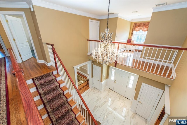 stairs with crown molding, a towering ceiling, and a chandelier