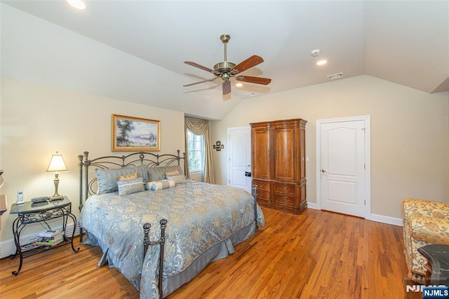 bedroom with ceiling fan, vaulted ceiling, and hardwood / wood-style floors