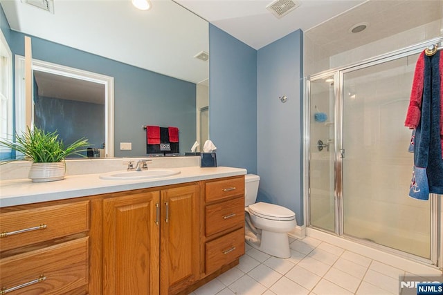 bathroom featuring vanity, tile patterned floors, toilet, and walk in shower