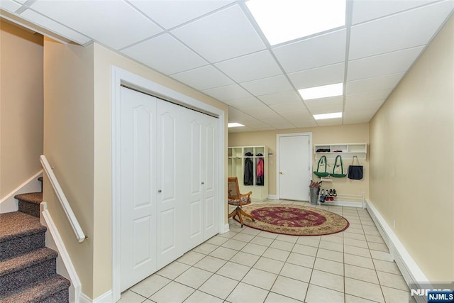 tiled entryway featuring a drop ceiling