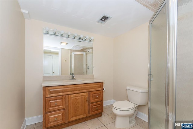 bathroom with vanity, toilet, tile patterned floors, and walk in shower