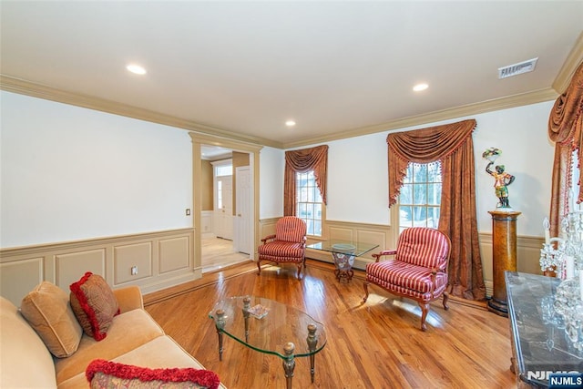 living room with crown molding and light wood-type flooring