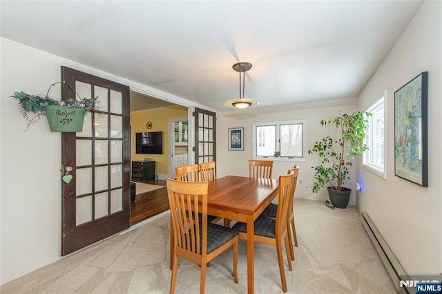 dining room with light carpet, baseboard heating, and french doors