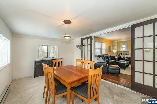 carpeted dining area featuring baseboard heating