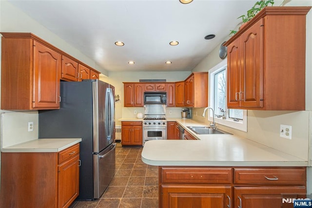 kitchen with sink, kitchen peninsula, and appliances with stainless steel finishes