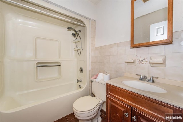 full bathroom with shower / washtub combination, tile walls, vanity, toilet, and tile patterned floors