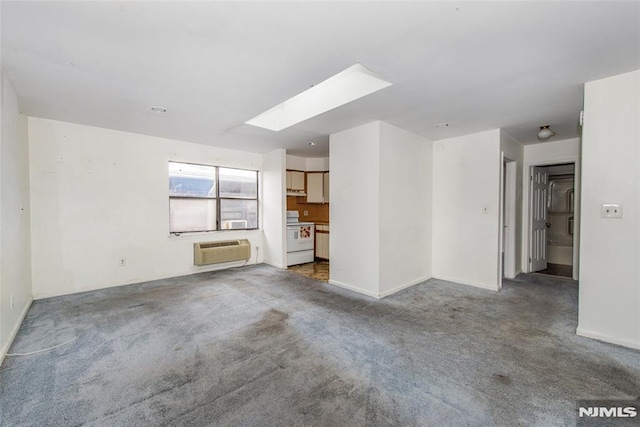 unfurnished living room featuring a skylight, a wall mounted AC, and carpet floors