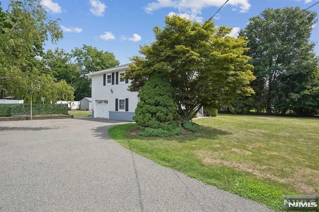 exterior space featuring a garage and a lawn