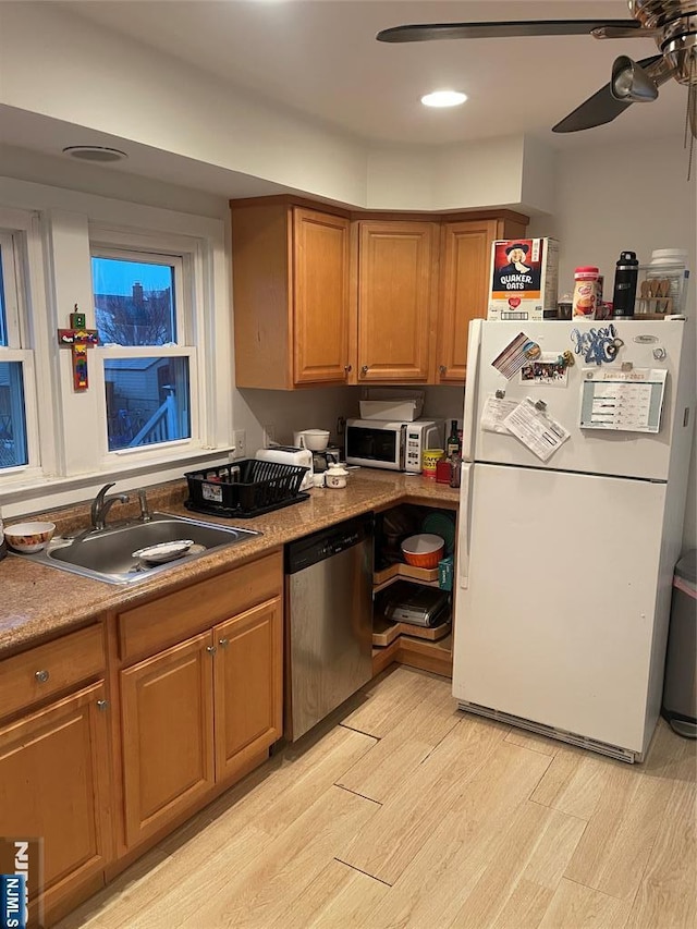 kitchen with sink, white fridge, stainless steel dishwasher, ceiling fan, and light hardwood / wood-style flooring