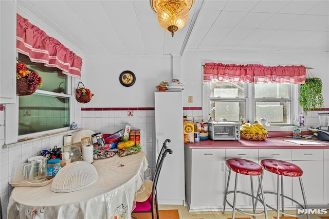 kitchen with tile walls and white cabinets