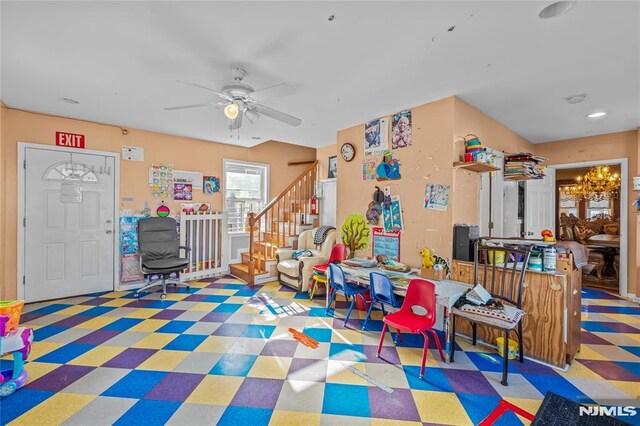 game room with ceiling fan with notable chandelier