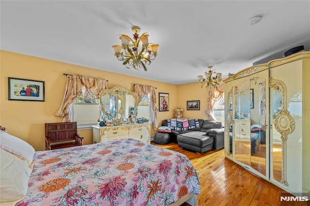 bedroom featuring a chandelier and light hardwood / wood-style flooring