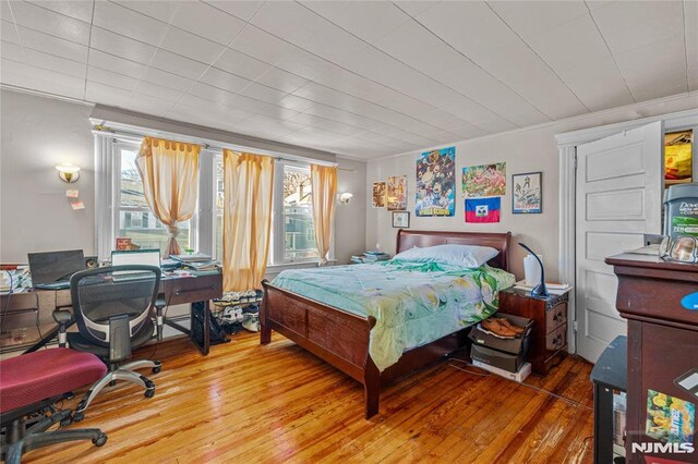 bedroom with hardwood / wood-style flooring and ornamental molding