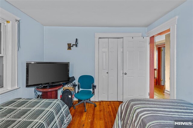 bedroom featuring hardwood / wood-style floors and a closet