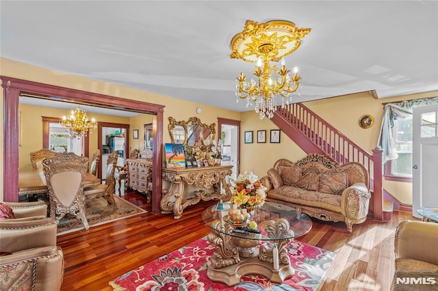 living room with plenty of natural light, wood-type flooring, and a notable chandelier