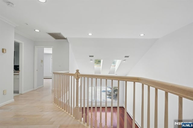 corridor featuring hardwood / wood-style flooring, a skylight, and a baseboard radiator