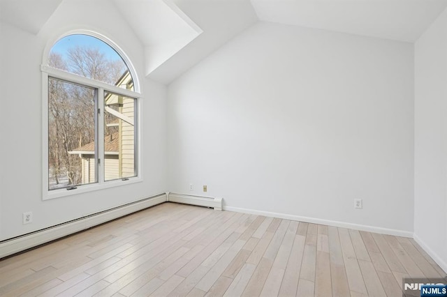 additional living space featuring vaulted ceiling, a baseboard heating unit, and light hardwood / wood-style flooring