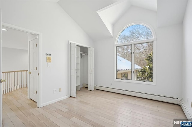 unfurnished bedroom with high vaulted ceiling, light wood-type flooring, and baseboard heating