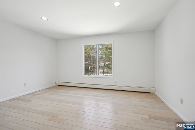 empty room with a baseboard heating unit and light wood-type flooring