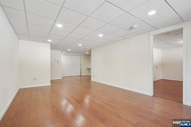 spare room featuring a paneled ceiling and hardwood / wood-style floors