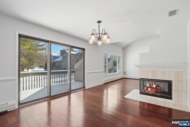 unfurnished living room featuring lofted ceiling, dark wood-type flooring, a chandelier, and a fireplace