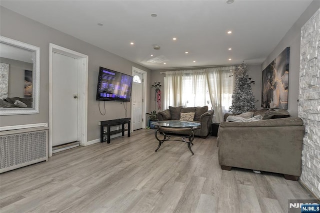 living room with radiator heating unit and light wood-type flooring