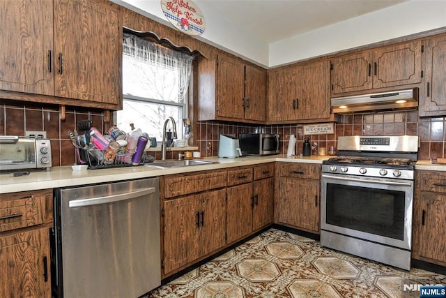 kitchen with appliances with stainless steel finishes, sink, and backsplash