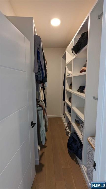 walk in closet with light hardwood / wood-style floors