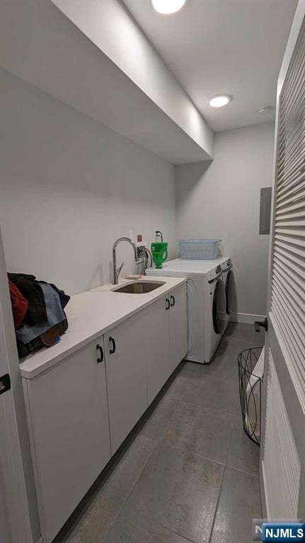 laundry room featuring cabinets, sink, washer and dryer, and dark tile patterned floors