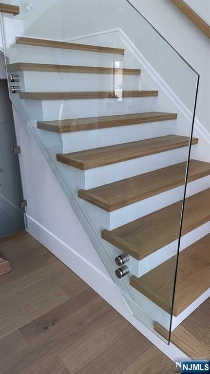 staircase with hardwood / wood-style flooring