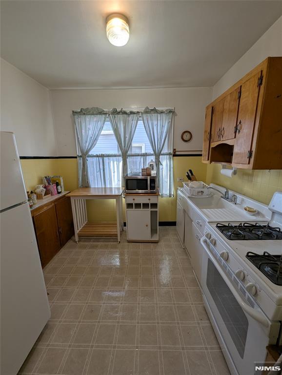 kitchen featuring sink, white appliances, and decorative backsplash