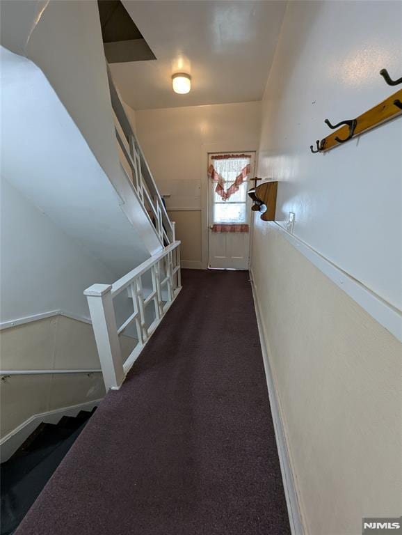 hallway featuring dark carpet