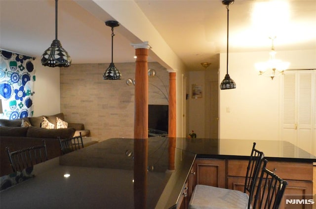 interior space with pendant lighting and ornate columns