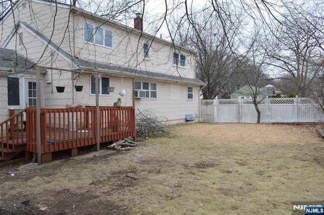 rear view of house featuring a deck and a lawn