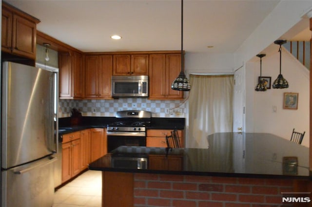 kitchen featuring tasteful backsplash, stainless steel appliances, kitchen peninsula, and pendant lighting