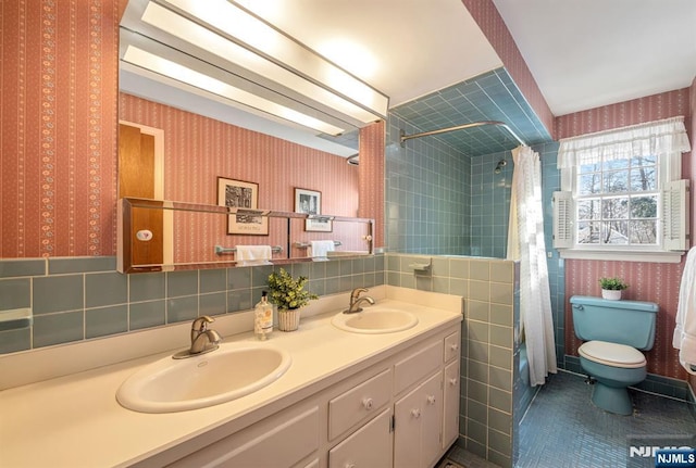 bathroom with tile patterned floors, toilet, tile walls, vanity, and curtained shower