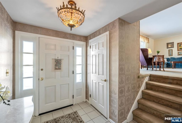 tiled foyer featuring an inviting chandelier