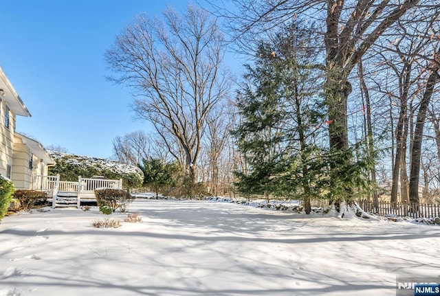 snowy yard featuring a deck