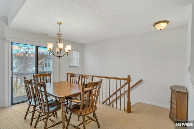 dining area with a chandelier, light carpet, and a textured ceiling