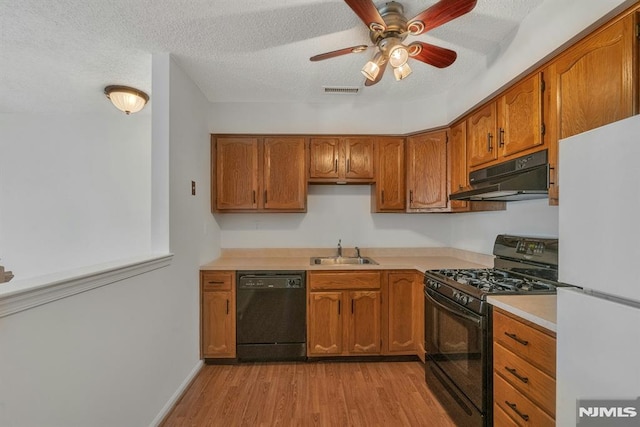 kitchen featuring sink, a textured ceiling, light hardwood / wood-style flooring, ceiling fan, and black appliances