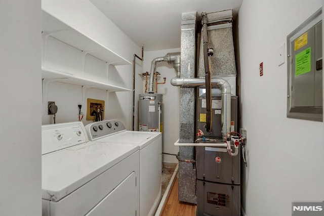 laundry area with electric panel, separate washer and dryer, water heater, and light hardwood / wood-style flooring