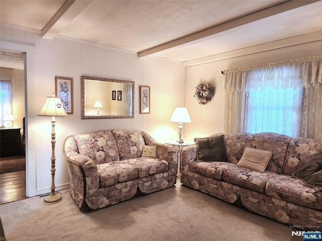 living room featuring beamed ceiling and carpet