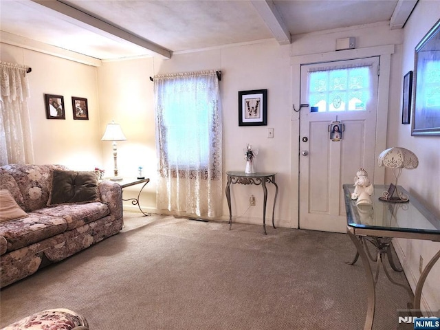 carpeted living room with beam ceiling