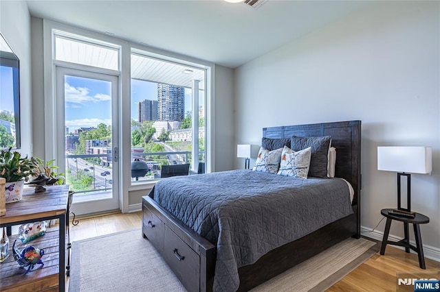 bedroom featuring access to exterior and light wood-type flooring