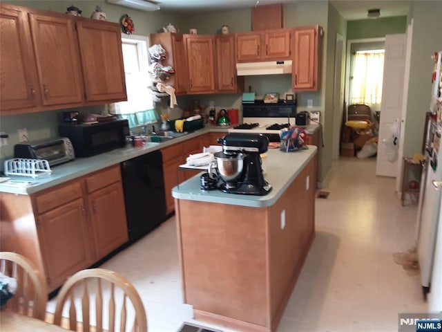 kitchen with sink, black appliances, and a kitchen island