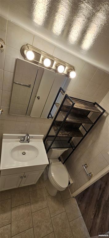 bathroom with sink, tile walls, backsplash, tile patterned flooring, and toilet