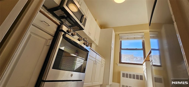 kitchen featuring white cabinetry, radiator, and wall oven