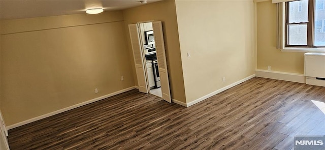 unfurnished room featuring dark hardwood / wood-style flooring