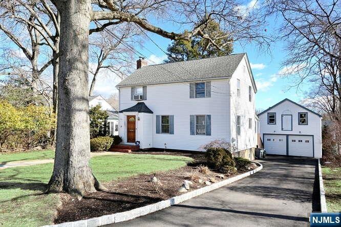 colonial-style house featuring a garage and a front yard